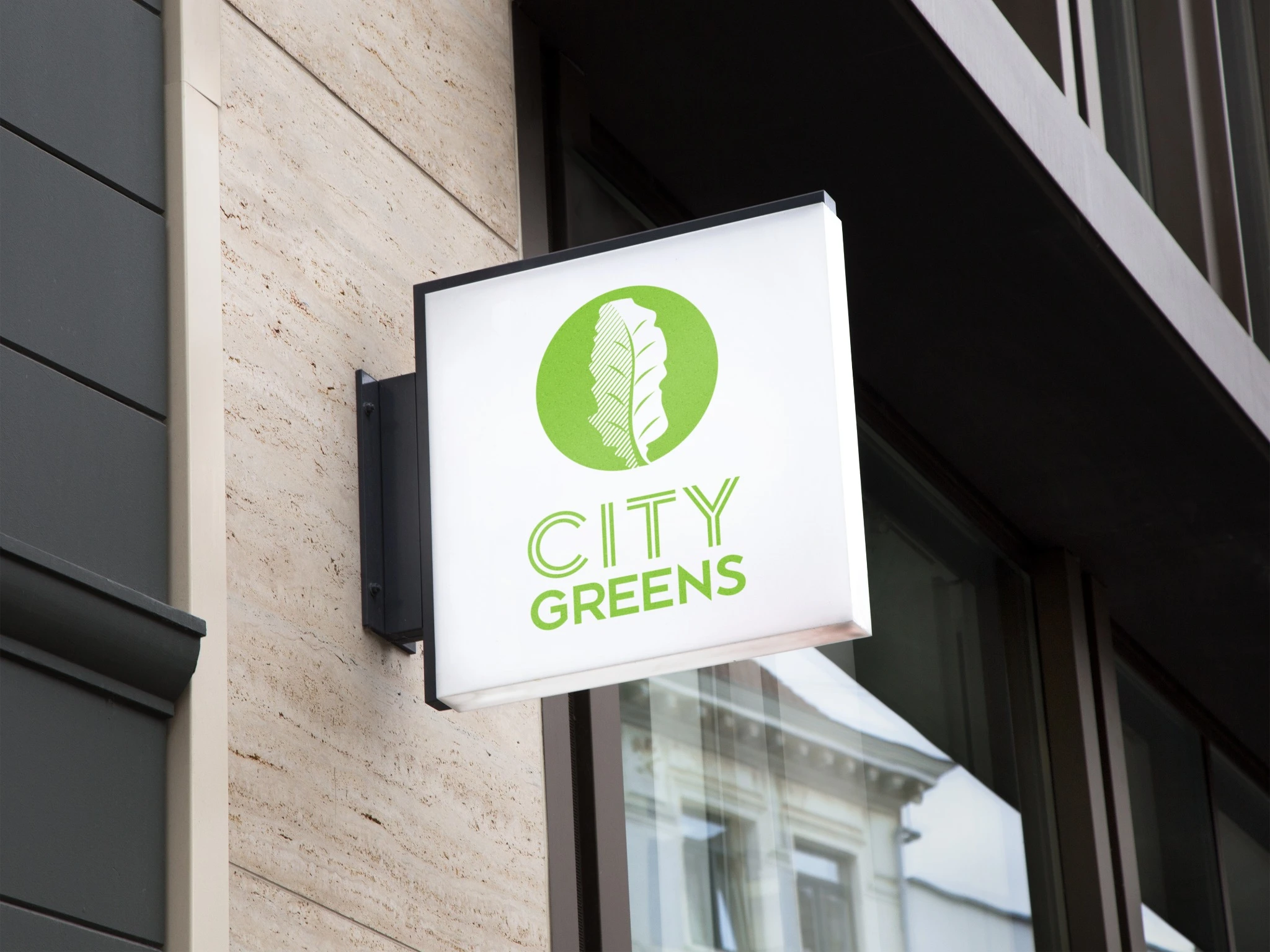 City Greens hanging storefront sign with a bright green leaf symbol and wordmark