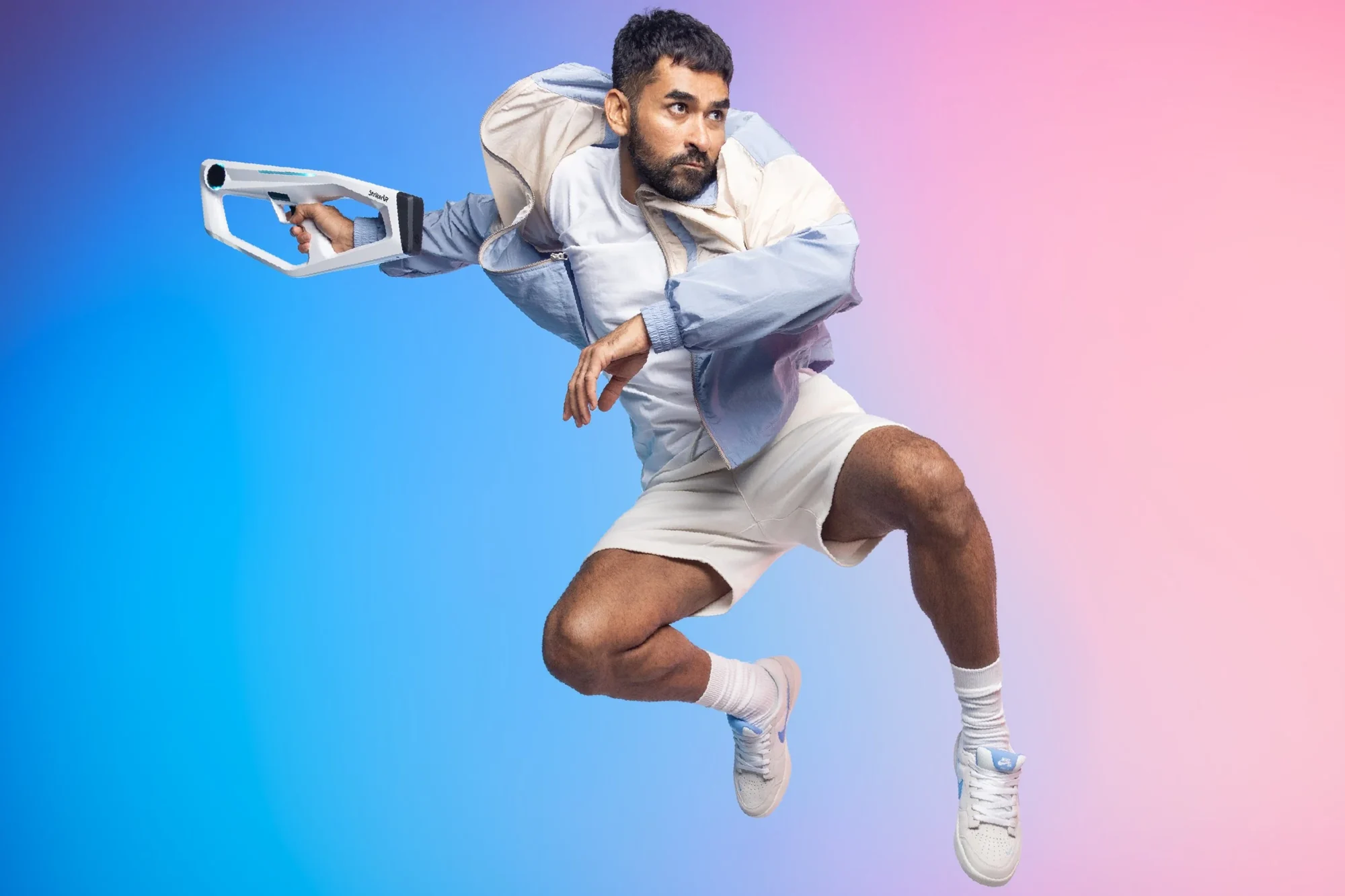Athlete leaping with a white Mavrik blaster against a blue and pink backdrop